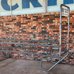 Unbranded metal shopping cart corral. Features galvanized steel tubular construction with a single-entry lane. Includes integrated overhead 'Please Re