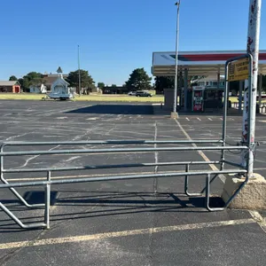 Metal shopping cart corral. Features tubular metal construction and an integrated sign holder with a yellow "Please Return Carts Here" sign. Dimension