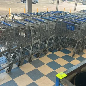 Metal wire shopping cart. Features gray wire basket construction with a blue plastic handle grip, child seat, and safety restraint strap. Equipped wit