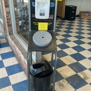 Triple S metal hand sanitizer and cart wipe stand. Features a gray textured metal frame, a Triple S automatic foam hand sanitizer dispenser, an integr