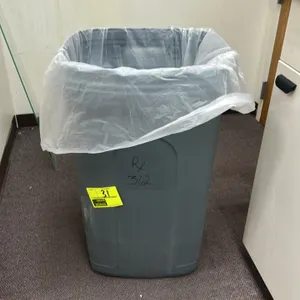 Polyethylene trash bin. Features a grey plastic construction with a rectangular design. Includes a plastic liner. Note: Contents not included.