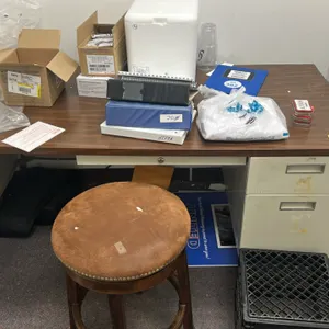 Metal desk and wooden barstool. Desk features a laminate top, center drawer, and 2-drawer pedestal. Measuring 60"x30". Stool features a round padded b