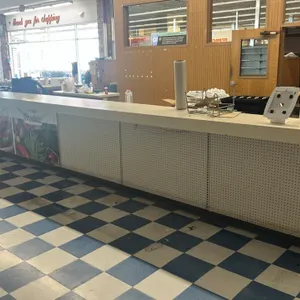 Laminate service counter set. Features a 340" x 160" L-shaped counter with under-counter cabinets, silver-tone drawers, pegboard front, and graphics. 