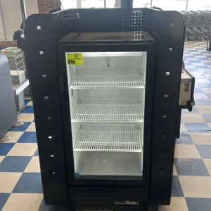 Portable candy and magazine display rack. Features black metal construction with pegboard panels, wire magazine holders, and slanted wire shelves. Mou