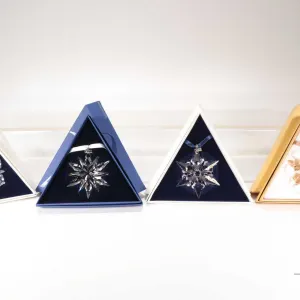 Four Swarovski Crystal collectible snowflakes including 1999, 2000, 2011 20th Anniversary and a 2010