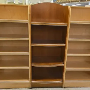 Laminate wood multi-tier merchandiser display lineup. Features three sections: a central darker-wood finish bay with an arched top, flanked by two out