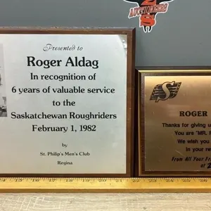 2 Plaques Celebrating Roger Aldag.