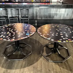 2 round tables, wooden with metal base , 47” diameter, 30” height, stickers included