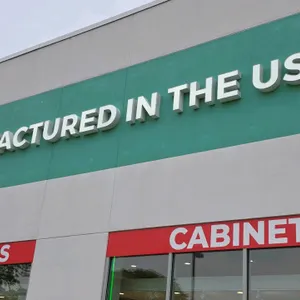Illuminated channel letters spelling 'MANUFACTURED IN THE USA'. Features white letter faces. Designed for exterior wall mounting. Note: Buyer is respo