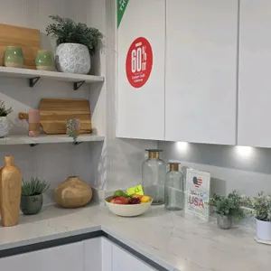 Assorted kitchen display decor. Includes wooden vases, ceramic vases, glass bottles with metallic collars, artificial plants in decorative pots, woode