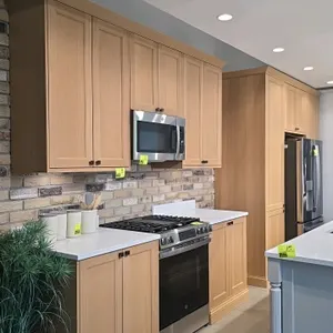 Infinity Plus kitchen cabinet set with Rhino quartz countertops. Features light wood shaker-style doors, upper and base cabinets for a range wall, and