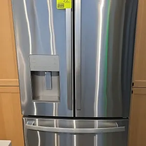 GE GFE26JMYFFS stainless steel French door refrigerator and freezer combo. Features exterior door ice and water dispenser, bottom pull-out freezer dra