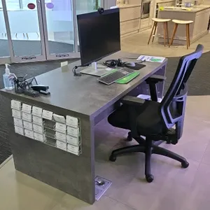 Laminate wood desk with Uline mesh back cushioned adjustable office chair. Desk features a gray weathered-look laminate finish and solid modesty panel
