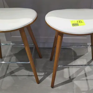 LumiSource leather padded bar stool. Features a white padded seat, curved wood frame, and tapered legs with a chrome-finished metal footrest. 26"H.