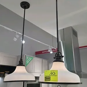 Pair of frosted glass and black pendant lights. Features bell-shaped frosted glass shades with black rim accents, black metal downrods, and matching c