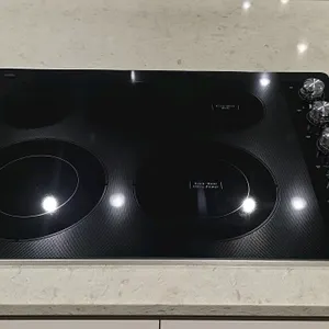KitchenAid KCES550HSS00 5-burner electric cooktop. Features a black glass ceramic surface with stainless steel trim and five radiant elements, includi
