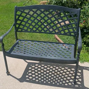 Metal outdoor bench. Features a lattice pattern seat and backrest, contoured back, and curved armrests with a dark finish. 45"x20"x38".