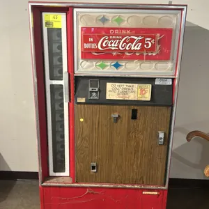 A Vintage Coca-Cola Bottle Vending Machine. (Cavalier, 1960s) A classic bottle vending machine featuring a woodgrain-accented front door, a glass prod