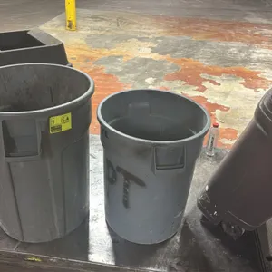 Assorted poly trash cans. Collection includes two grey round utility trash cans, one brown wheeled slim-style trash can, and one dark brown square tra