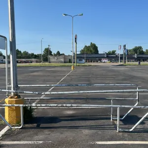 Metal shopping cart corral. Features tubular metal construction and an integrated sign holder frame. Measures 34"W x 132"L. Note: Concrete base and li