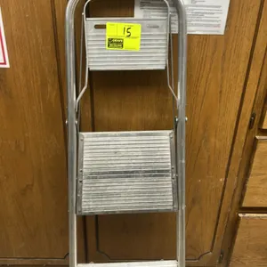 Metal 2-step folding ladder. Features a lightweight aluminum frame, folding design for compact storage, slip-resistant step treads, and a high handrai