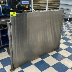 Stainless steel checkout lane partition wall. Features a textured stainless steel panel mounted between two chrome-finished end posts. Designed for fl
