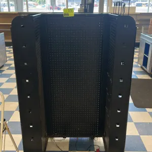 Portable candy and magazine display rack. Features black metal construction, multi-sided pegboard panels, tiered wire display shelving, and metal peg 