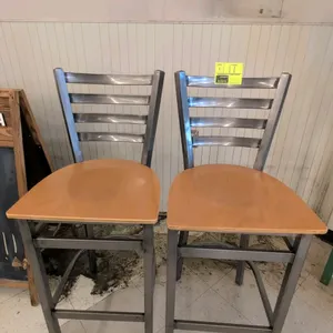 Metal bar chair featuring a ladder-style backrest, clear-coat metal frame, and a light brown laminate wood seat. Equipped with integrated footrest sup