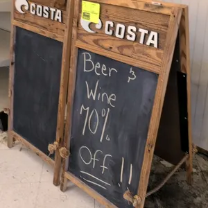 Costa wood A-frame chalkboard sign. Features rustic wood frame construction, a chalkboard writing surface, and dimensional 'COSTA' branding with logo 