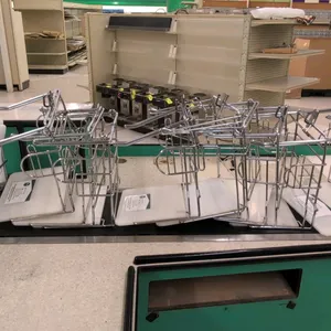 Metal and poly T-shirt bag stand. Features a chrome wire frame with dual hanging arms, center hook, and side racks. Mounted on a durable white polyeth