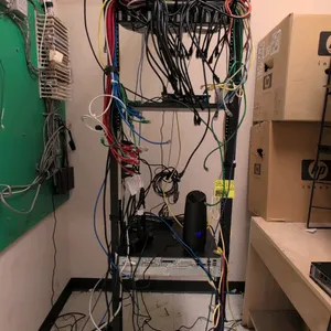 7'H metal open-frame IT rack. Includes (2) Avaya 1100PSE Power Sum Panels, a Tripp Lite Internet Office UPS, and assorted network patch cables. Mounte
