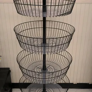 Metal 4-tier wire basket merchandise display rack. Features four round metal wire baskets with clear plastic bottom liners. Equipped with a top card s