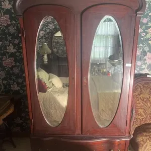 armoire features oval beveled mirror doors and