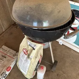 Weber grill with charcoal and lighter fluid.