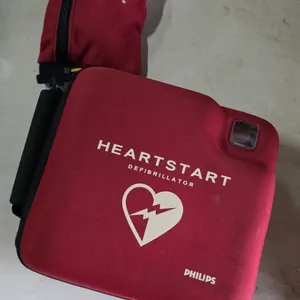 Philips HeartStart defibrillator. Features a text display screen. Includes AMCO aftermarket battery (P/N: GL785, expiration date 2025-08-24), a packag