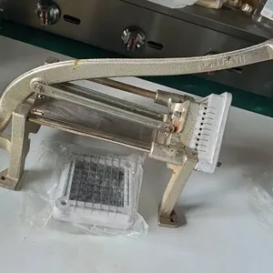 Vollrath manual french fry cutter. Features cast metal frame construction, manual lever arm with blue grip, and tabletop mount legs. Includes two extr