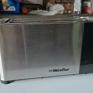 Mueller MT-440SS UltraToast 4-slice toaster. Features stainless steel construction, two extra-wide long slots, and a black control panel with cancel, 