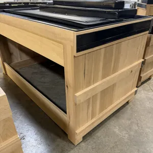 JSI Store Fixtures wooden produce and bakery display island. Features a wood-paneled exterior and a black plastic two-tier riser insert. This item loc