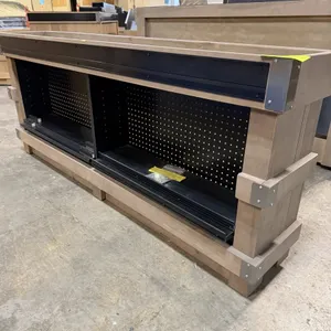 JSI Store Fixtures wooden end cap table. Features a wooden frame with metal accent corner brackets, black pegboard backing, and includes 4 storage she