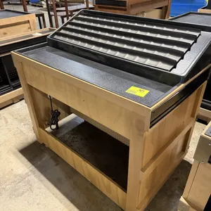 JSI Store Fixtures wooden produce and bakery display table. Features a slanted black plastic merchandising tray, pegboard bottom shelf, and integrated