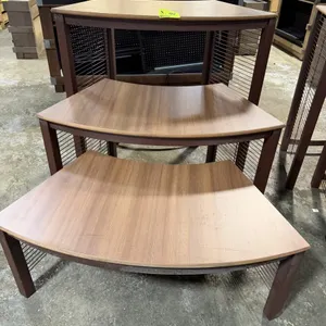 JSI 3-piece nested step-up riser display set. Features three nesting curved display tables with wood-grain laminate tops and brown-finished metal fram