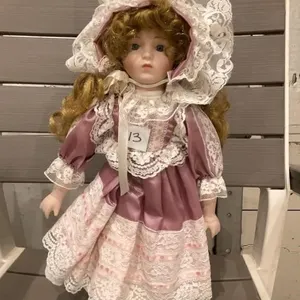 Porcelain doll on stand. 16T