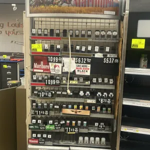 Marlboro branded metal multi-tier tobacco merchandiser. Features an illuminated top header sign, adjustable shelving tiers with spring-loaded product 
