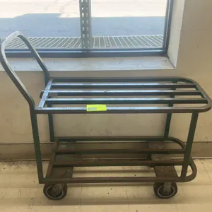 Metal 2-tier utility cart. Features slatted steel shelves and an integrated push handle. 42"L. Mounted on four casters.