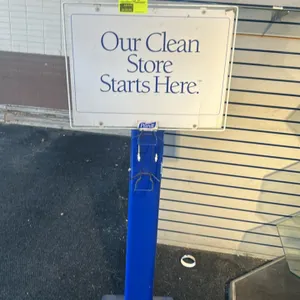 Purell metal sanitizing wipe stand. Features a blue finished metal post and base, an integrated wire basket holder designed for a sanitizing wipe cani