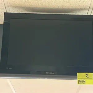 Toshiba 25" HD TV. Features a black bezel with a silver-tone accent bar. Wall-mounted. Remote control not included.