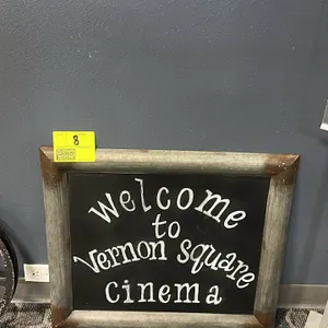 Decorative chalkboard sign. Features a galvanized metal frame with weathered rusted corners and a black chalkboard face featuring white lettering that