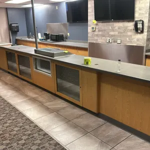 Custom laminate built-in concession stand counter. Features a wood-grain laminate base with a grey laminate countertop, front-facing sliding glass dis