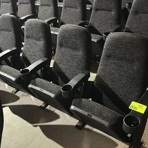 Floor-mounted movie theater seating row. Features a 4-seat configuration with dark textured cloth cushioned seats and backs. Equipped with folding sea