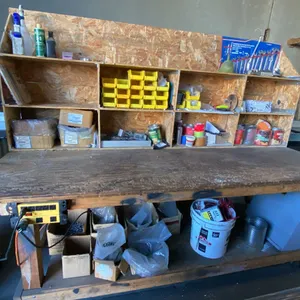 WOODEN MOBILE WORKBENCH WITH ASSORTED SHOP ITEMS- HARDWARE, ELECTRICAL ITEMS, WRENCHES & MORE